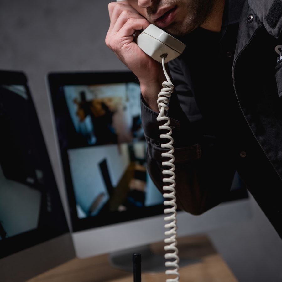 partial view of guard talking on telephone at workspace
